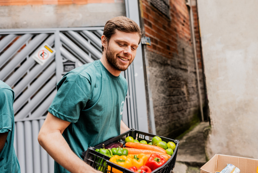 Man holding a crate of vegetables