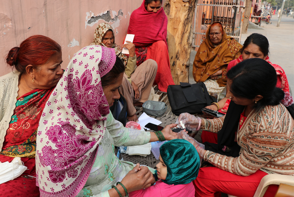 Researchers from The George Institute testing blood sugar during the Impact Diabetes project