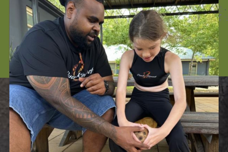 Xavier demonstrating how to carve the flesh out of a coconut