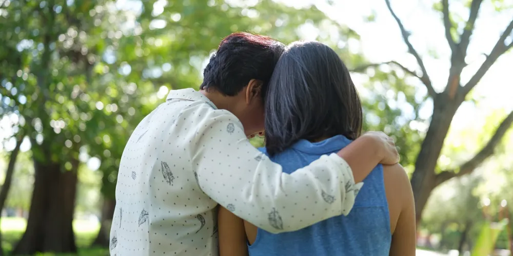 Women hugging facing away from camera