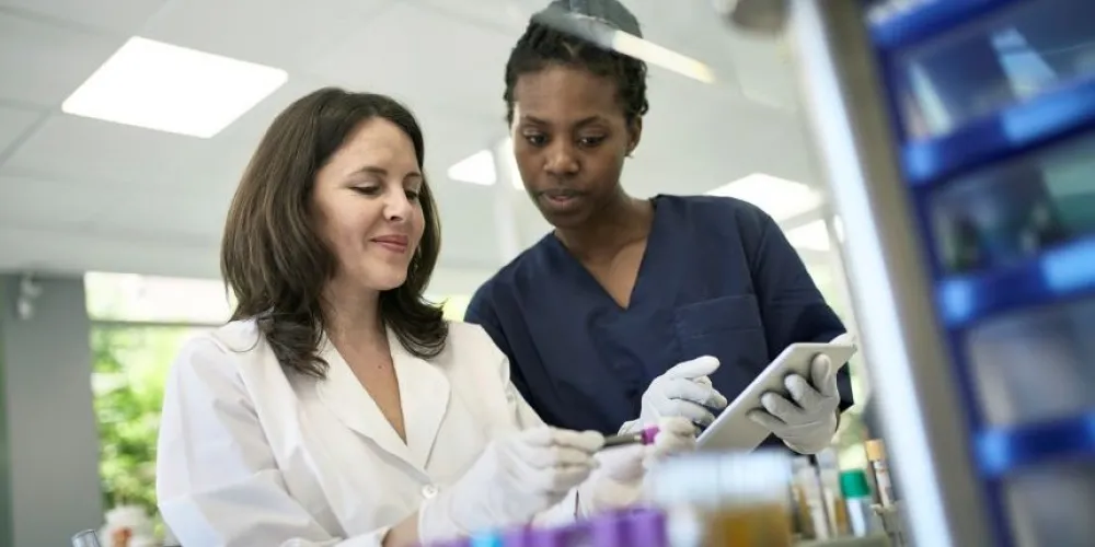 Two women analysis blood samples in laboratory setting