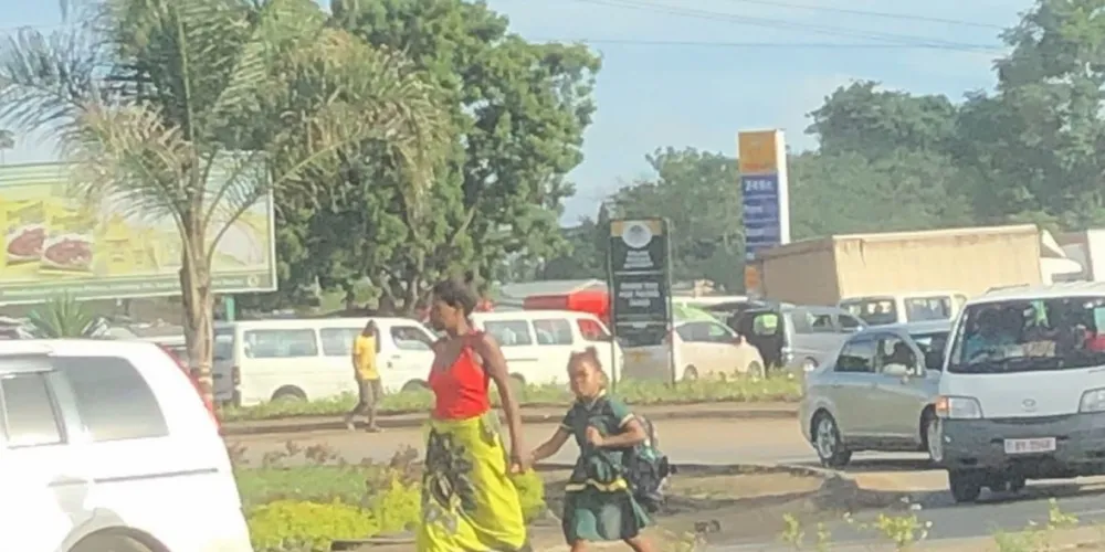Mother and daughter walking along road in Malawi