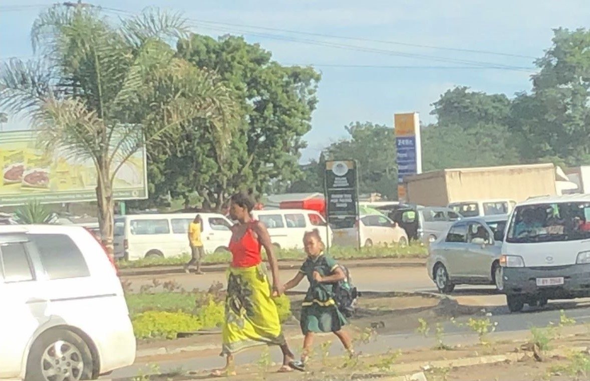 Mother and daughter walking along road in Malawi