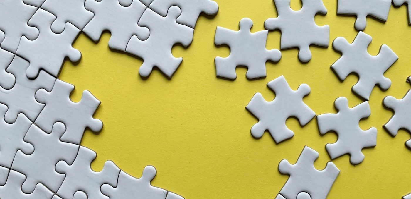 JIgsaw puzzle pieces being put together on a yellow background
